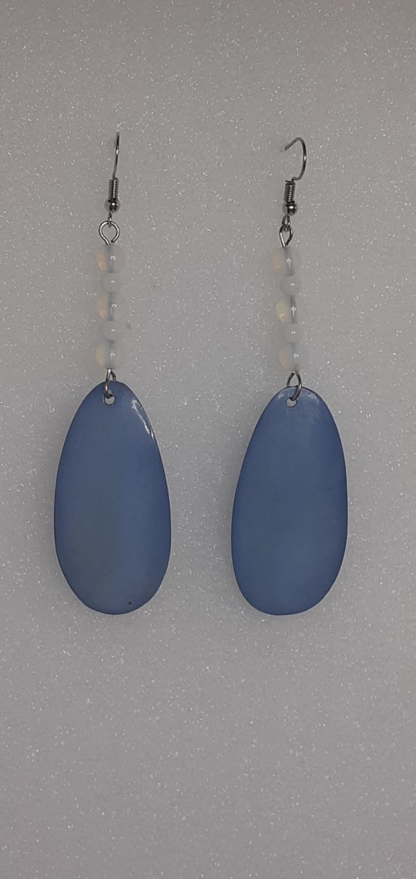 Boucles d'oreilles longues fabriquées avec des perles en verre et un pendentif en nacre bleu.