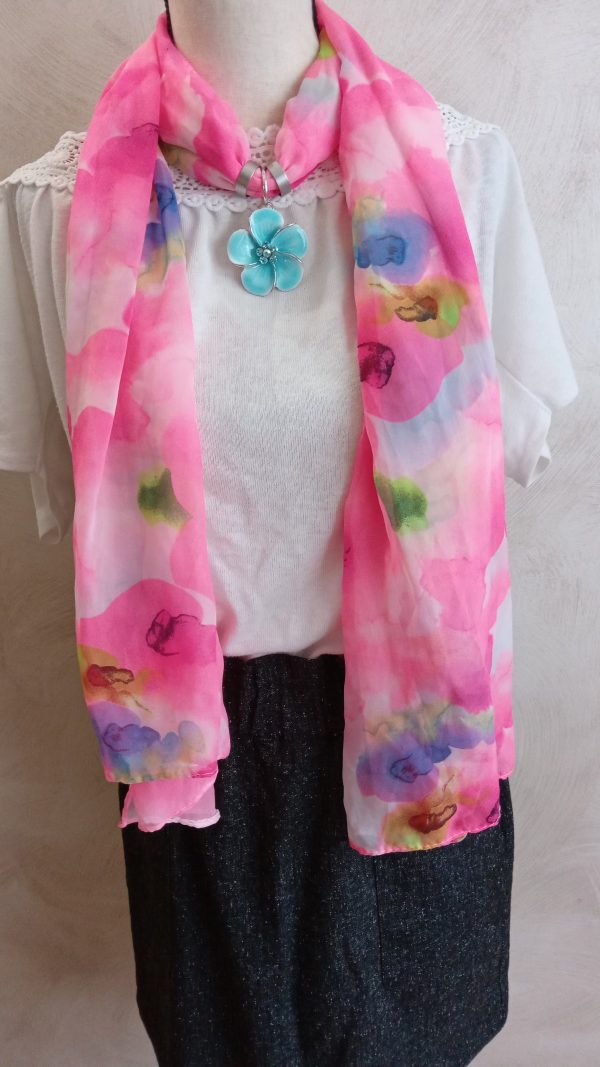 Foulard rose, pendentif fleur bleue.