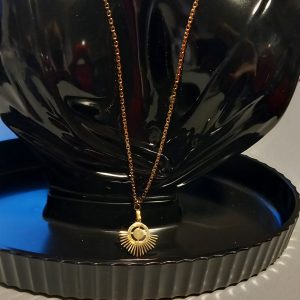 Collier en acier inoxydable fabriqué avec une chaîne fine dorée et un pendentif.