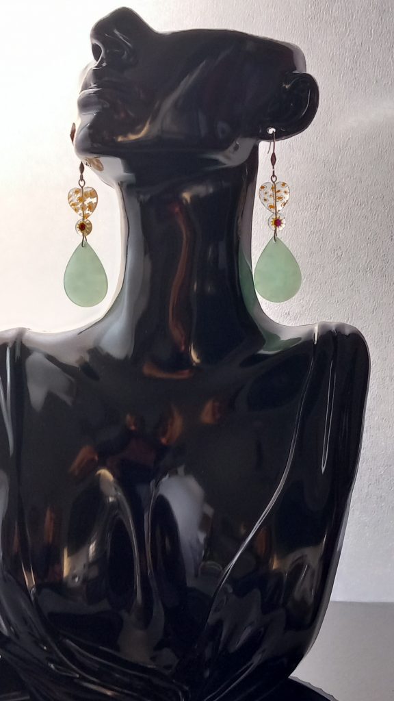 Boucles d'oreilles fabriquées en acier inoxydable avec perles cœur en verre et des pendentifs en acétate.