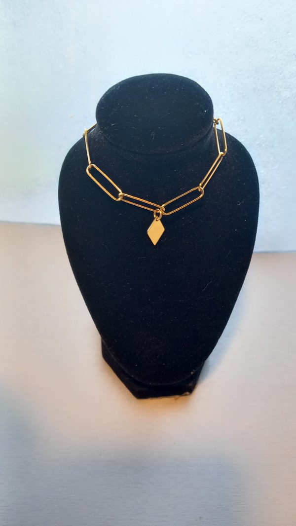Bracelet fabriqué avec une chaîne trombone en acier inoxydable dorée avec une breloque.